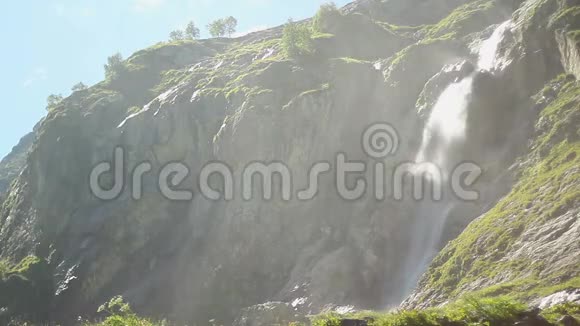 高山中的高瀑布风吹得水花四溅视频的预览图