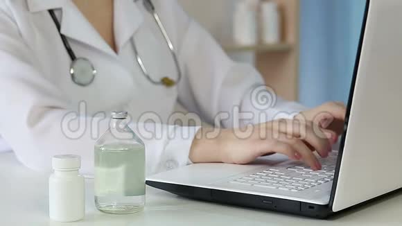 医生在笔记本电脑键盘上打字检查药瓶信息视频的预览图
