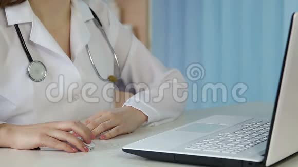 女医生在办公室里用手提电脑点击鼠标敲键盘视频的预览图