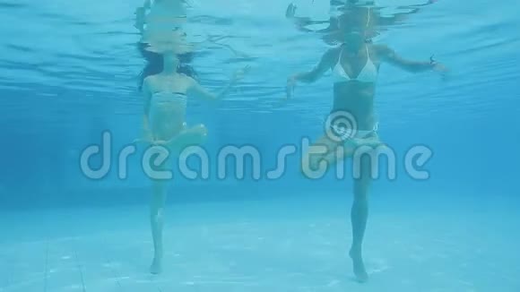 两个美丽的白种人女人在游泳池里做瑜伽莲花姿势视频的预览图