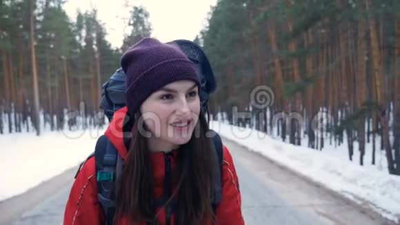 特写镜头年轻的Hiker女性背包在一条空路上行走慢动作视频的预览图