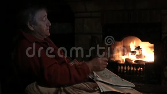 坐在壁炉前拿着报纸的老人视频的预览图