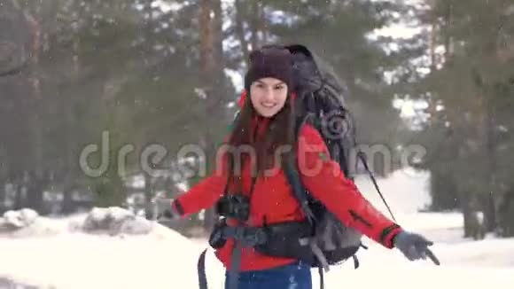 女孩在大雪下转身旅行者冬季森林中的Hiker正面肖像徒步旅行爱情纯洁自由视频的预览图