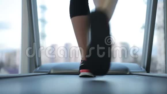女性运动员脚在跑步机上行走女性停止并完成锻炼视频的预览图