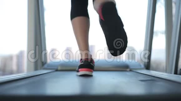 女性的脚在跑步机上跑得很快努力工作并达到目标视频的预览图