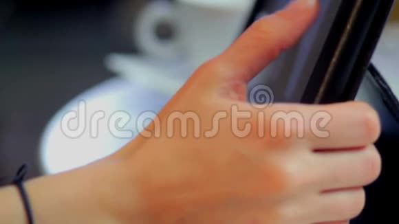 女人看网络视频手指滚动喝咖啡杯视频的预览图
