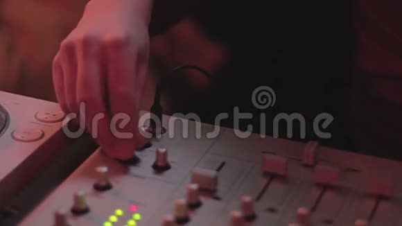 耳机中的男性剪影站在调音台附近DJ播放音乐视频的预览图