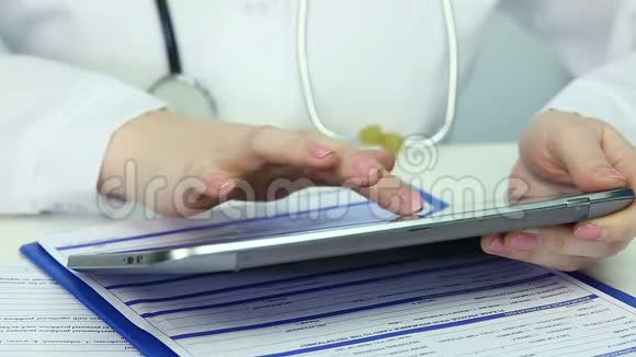 女性手使用平板电脑医生在办公室工作滑动滚动页视频的预览图