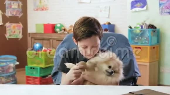 可爱的小男孩猥亵了他的愤怒的小狗斯皮茨试图玩它视频的预览图