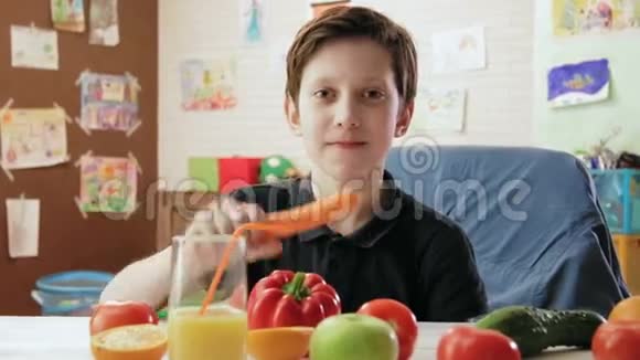 可爱的小男孩吃胡萝卜看着相机视频的预览图