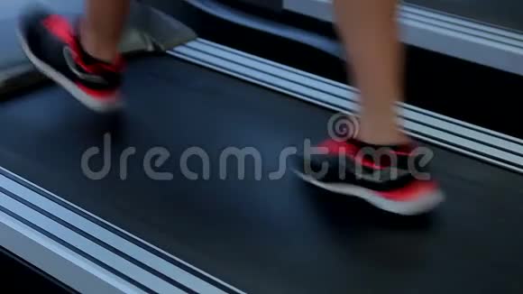 女性的脚在跑步机上行走女性完成锻炼常规达到目标视频的预览图