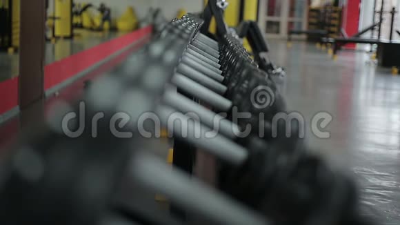 健身俱乐部积极训练所准备的运动器材球架聚焦镜头视频的预览图