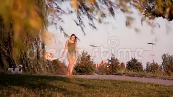 日落时分可爱的女孩和狗在公园里散步视频的预览图