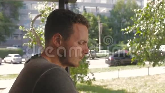 悲伤的人在阳光明媚的日子在露台上抽烟视频的预览图