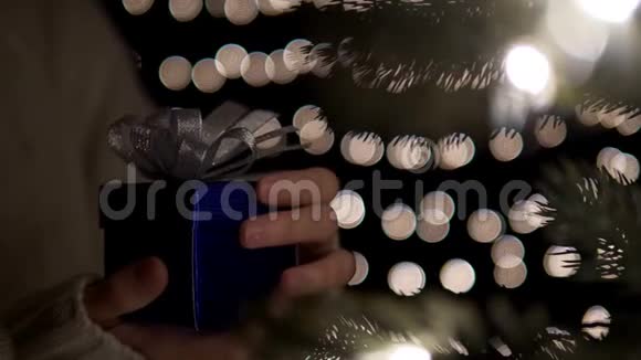 boke灯光背景下的女性开放蓝色圣诞礼盒视频的预览图