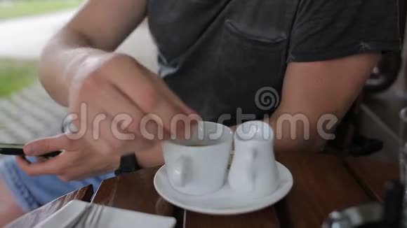 一个拿着电话的男人在咖啡馆倒咖啡喝视频的预览图