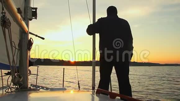 站在帆船上看日落的人剪影视频的预览图