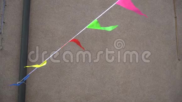 色彩鲜艳的横幅人群控制绳节日三角装饰靠水泥墙视频的预览图