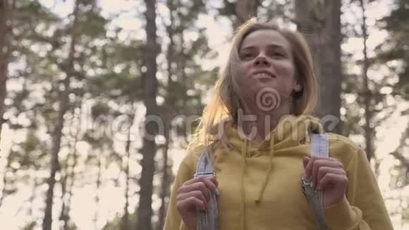 快乐的年轻微笑的女人在森林里旅行视频的预览图