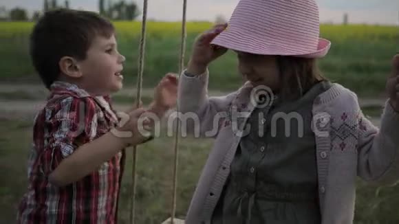 男孩为女孩戴帽子头戴巴拿马兄妹双胞胎玩耍快乐的童年活跃的游戏孩子们在视频的预览图