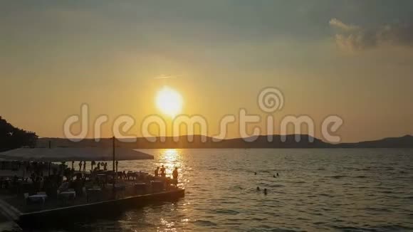 在希腊的皮洛斯人们在阳光下剪影享受暑假视频的预览图