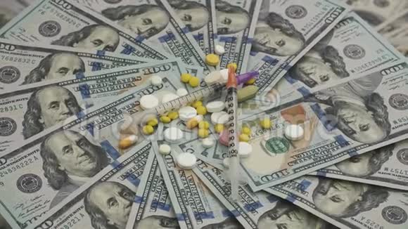 在金钱上旋转的混合药丸和注射器的激增医疗成本概念视频的预览图