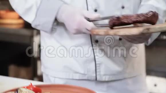 牛排从烧烤中脱下来厨师在盘子里摆菜视频的预览图