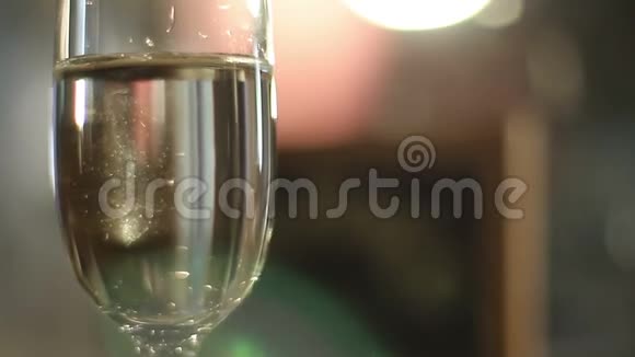闪烁的光映在一个装满香槟的玻璃杯上视频的预览图