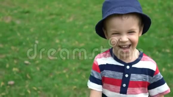 快乐的男孩在公园的草地上奔跑视频的预览图