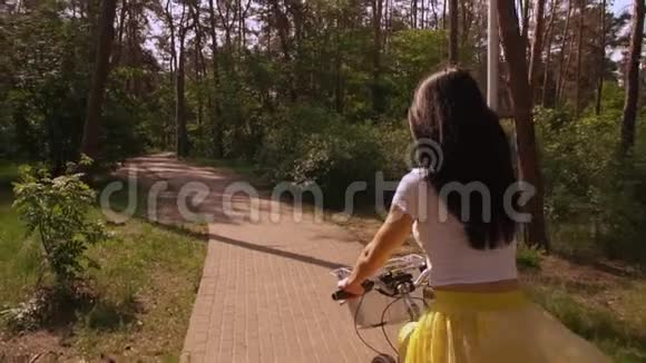 女骑自行车在公园里视频的预览图