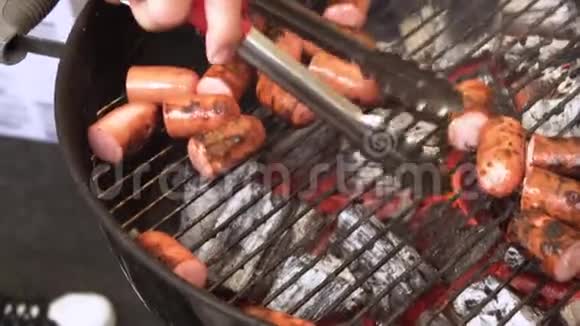 烹饪框架烤架上有美味的食物厨师从烤架上拿香肠视频的预览图