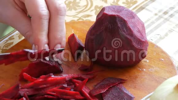 女性的手用刀子割菜板上的甜菜根视频的预览图