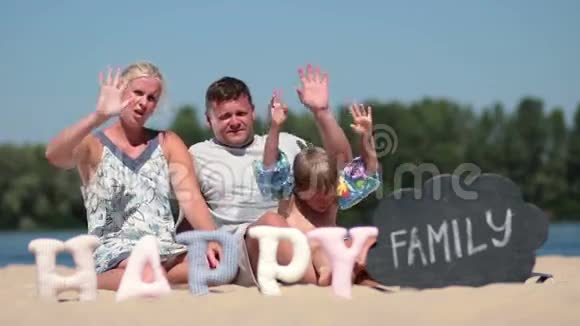 快乐的一家人坐在沙滩上打招呼视频的预览图