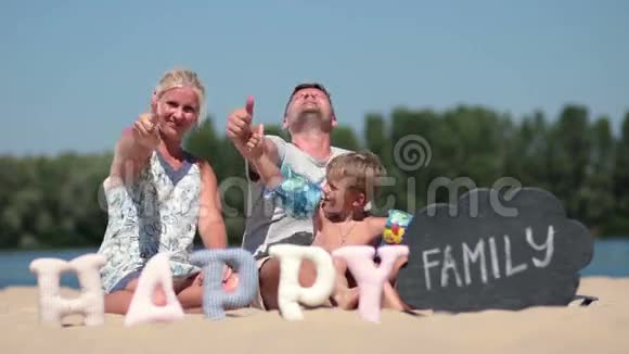一家人坐在沙滩上竖起大拇指视频的预览图