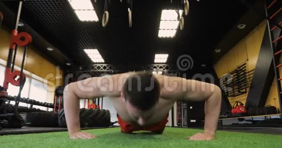 俯卧撑男子健身模式训练俯卧撑肌肉发达的年轻人在运动垫上做俯卧撑视频的预览图