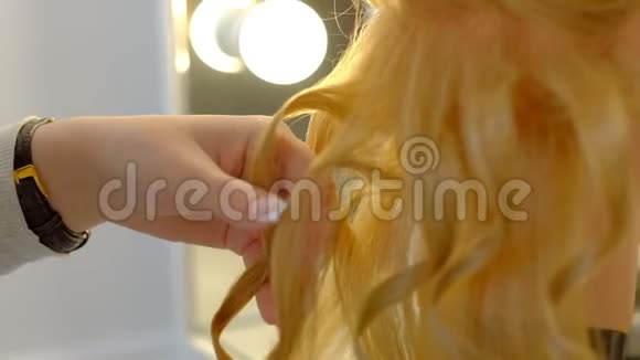 女学生理发师在浅色美发店做假头发留长金发视频的预览图