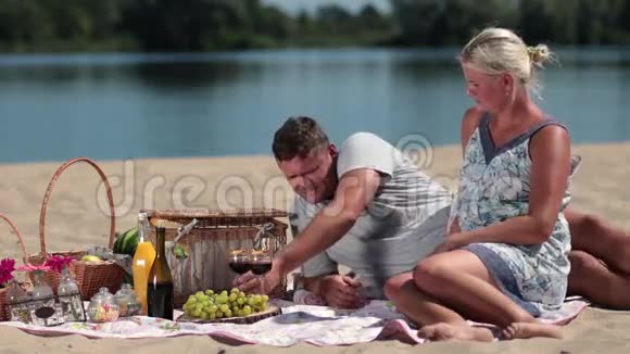 年轻夫妇在野餐时喝红酒视频的预览图