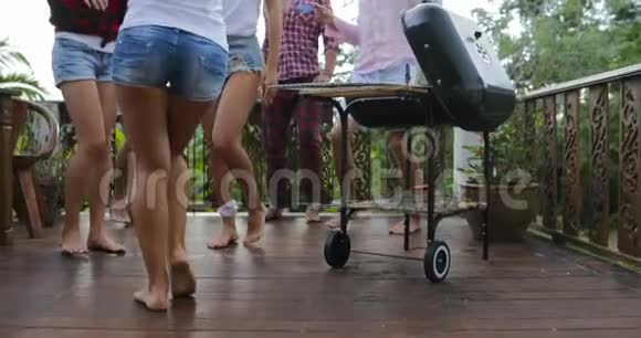 青少年边做烧烤边跳舞在夏日露台上聚会有派对腿特写镜头视频的预览图
