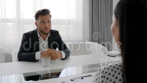 沮丧的男性肖像不快乐的男人和坐在桌子旁的心理学家的谈话沮丧的男人视频的预览图