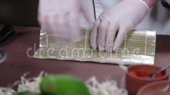 寿司主厨在竹席上制作寿司卷视频的预览图