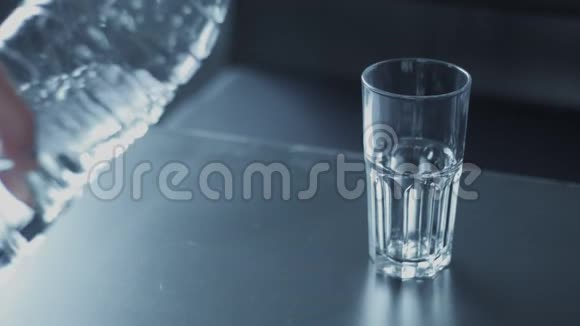 用瓶子里的水灌满玻璃杯视频的预览图