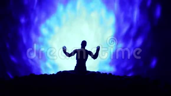 一个人的剪影与莲花姿态在地面上色调抽象的背景瑜伽莲花冥想姿势视频的预览图