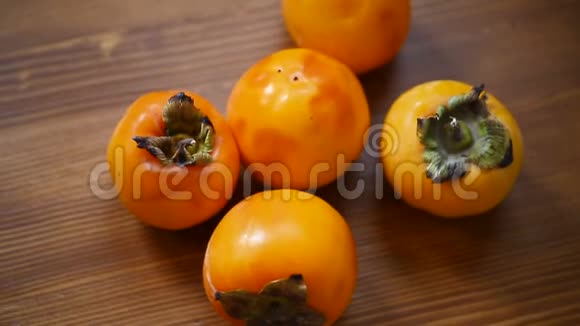 木制背景下成熟的异国橘子柿子视频的预览图
