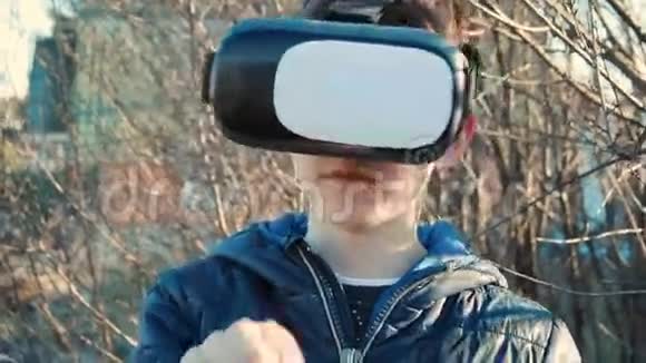 在他家后院里小男孩戴着虚拟现实耳机视频的预览图