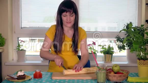 孕妇用刀在切割板上切面包视频的预览图