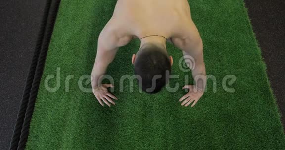运动员在健身房锻炼肌肉发达的年轻人在运动垫上做俯卧撑视频的预览图