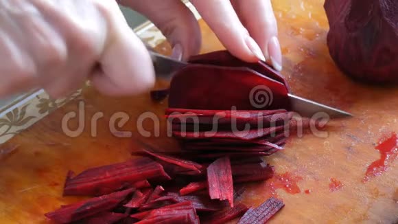 女性的手用刀子割菜板上的甜菜根视频的预览图