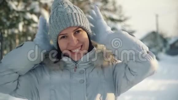 冬天快乐的年轻女子在郊区为照相机摆姿势视频的预览图