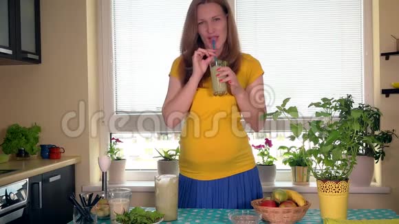 幸福的未来妈妈喝水果鸡尾酒抚摸她的大肚子视频的预览图