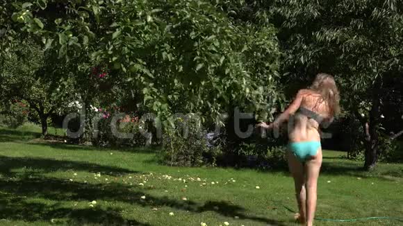 男人在花园院子里用水管捕捉和喷洒穿内衣的女人4K视频的预览图